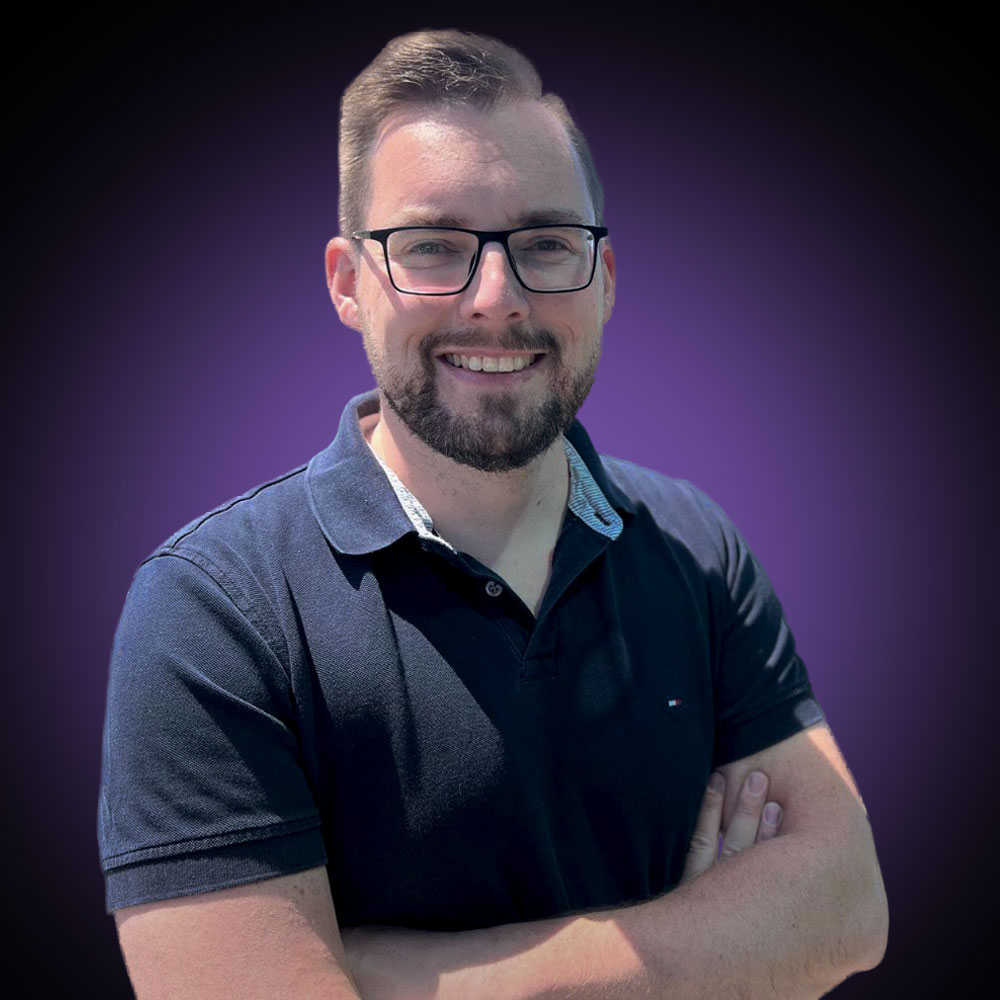 Porträtfoto von Marco Gräber vor einem lila Hintergrund.